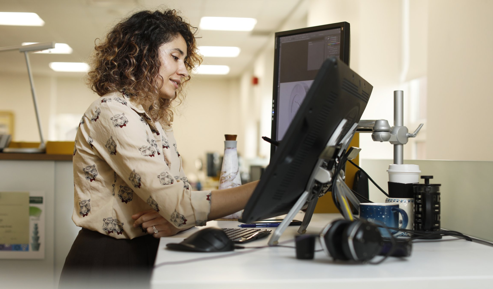 Une femme travaillant à un bureau debout.