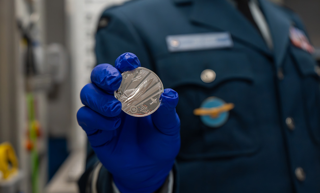 image Lieutenant-General Eric Kenny holds $20 Silver RCAF Centennial coin