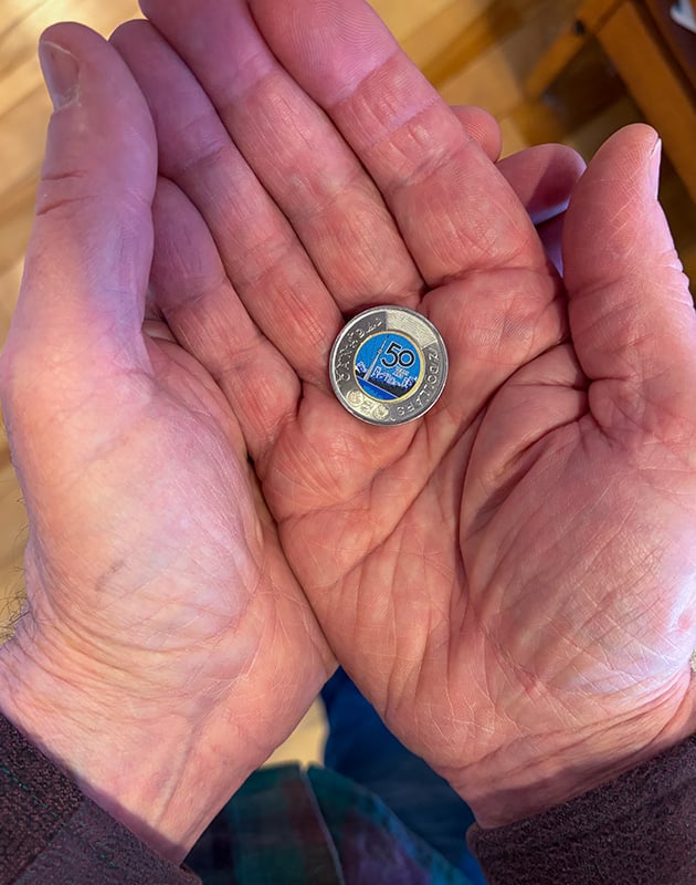 Canadian illustrator Carl Wiens holding CN Tower $2 coin