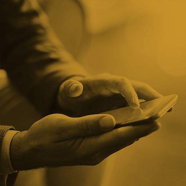 Photo of hands holding a phone. Photo of hands holding a phone.